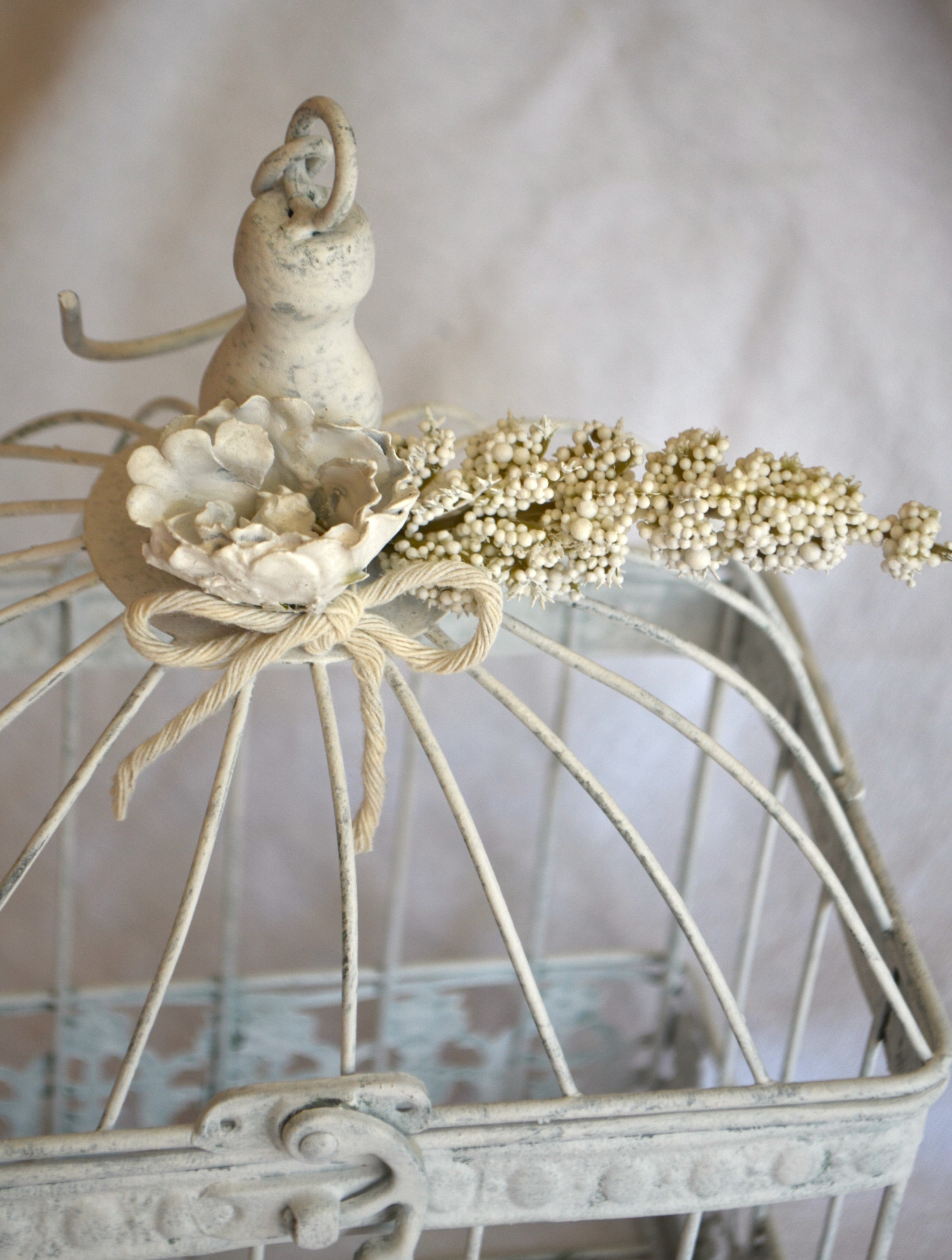 Detalle Jaula decorativa de metal estilo vintage romántico con detalles de flores de cerámica blancas ideal para decoración de interiores, terraza o jardines  con aire provenzal. Lily Garden & deco